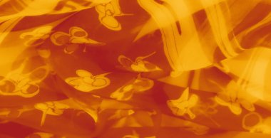 Turuncu kumaş bulanıklığı zarif çiçek motifleri sergiliyor. Yumuşak dokusu ve katları sıcaklığı ve karmaşıklığı çağrıştırıyor. Bu da onu yaratıcı tasarımlar için ideal kılıyor..