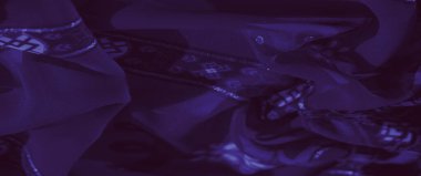 Bulanık, çiçeğe benzeyen narin desenleri ve simetrik tasarımları olan zengin mor kumaş zarafet ve detayların sanatsal bir karışımını sunar..