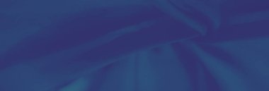 Bulanık mavi kumaş dalgaları ve kırışıklıkları zarif ve dinamik bir bileşim oluşturarak dokuyu ve derinliği vurguluyor. Şık görsel ve sanatsal tasarımlar için uygundur.