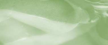 Işıldayan yüzeyi ve yumuşak kıvrımları olan yeşil bir kumaş. Tekstil karmaşık dokuma kalıplarını ortaya çıkarıyor, resme ruhani ve hava kalitesi veriyor..