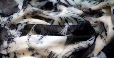 Bulanık etki, şeffaf kıvrımlar ve şeffaf katmanlar oluşturarak yumuşak, dinamik bir görsel akış oluşturan saf kumaş üzerinde siyah ve beyaz desenlerin bir karışımını gösterir.