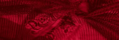 Şebeke ve ağ desenli kırmızı tekstil bulanıklığı kalın dokusunu çarpıcı bir şekilde gösteriyor. Tasarım, moda veya dekor kavramları için mükemmel zengin bir kumaş..