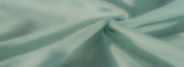 Nane rengi kumaş bulanık ince kareli ızgaralar ve akan kıvrımlar yayılmış ışıklandırmada modern bir estetik gösteriyor..