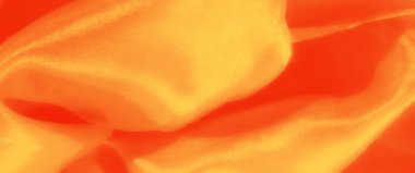 Canlı turuncu saten kumaş pürüzsüz, parlak bir dokuya sahip kıvrımlar sergiliyor. Parlak röfleler bir sıcaklık ve zarafet hissi yaratır..