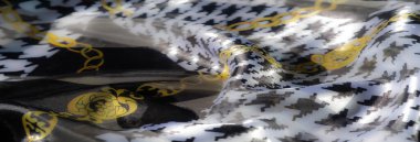 Çiçekli aksanlar ve çizgili detaylarla süslenmiş turuncu kumaşın yumuşak kıvrımlarını bulanıklaştırarak sanatsal dekor için canlı ve zarif bir tekstil oluşturuyor..