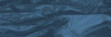 Bol desenli ve çiçekli desenli mavi kumaş bulanıklığı. Yumuşak kıvrımlar ve narin tasarım sanatsal bir karmaşıklığı çağrıştırıyor.