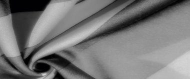 Bulanık: Bu gri pullu kumaşın kıvrımları ve kıvrımları karanlık ve aydınlık alanların uyumlu bir karışımını oluşturur, pürüzsüz dokusu sofistike ve derinlik hissi katar.