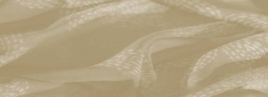 Bulanık kıvrımlar ve bej kumaştaki narin çiçek desenleri sakinleştirici, yumuşak bir doku oluşturur. Kumaşlar zariflik ve karmaşık tasarımlar lüks ama abartısız bir ücret sağlar.