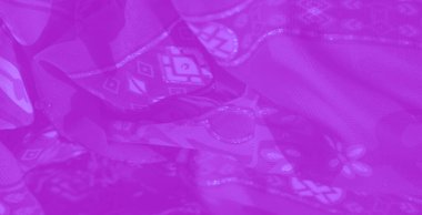 Zarif çiçek motifleri ve soyut geometrik şekillerle mor kumaşın bulanık görüntüsü, yaratıcı uygulamalar için yumuşak dokuyu ve karmaşık tasarım unsurlarını vurguluyor.