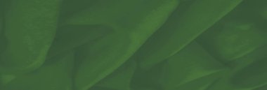 Görüntü. Narin kıvrımları ve ışık ve gölgenin yumuşak geçişleri olan canlı yeşil bir kumaş. Sıvı tasarımı ve pürüzsüz yüzey sakin bir sofistike hissi uyandırıyor..