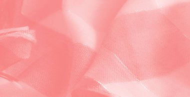 Karmaşık yıpranmış iplikleri olan yumuşak mercan renkli kumaş bulanıklığı, ışığı yansıtıyor ve tasarım ilhamları veya arka planlar için lüks, sıcak bir ortam yaratıyor.