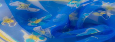 Bulanık Bu kumaş görüntü canlı mavi, beyaz çiçek aksanlarının dinamik bir karışımı ve karşıt sarı detaylar, karmaşık ve modern bir tekstil bileşimi oluşturur.