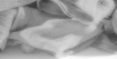 Görüntü narin beyaz kumaşın katmanlı dokusunu ortaya çıkarır, yumuşak kıvrımlar içine yumuşak gölgeler bırakır. Bu sakinleştirici tasarımın kusursuz, zarif ve dingin bir ışık kalitesi var..