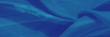 Bulanık, karmaşık çiçekli ve çizgili desenli mavi bir kumaş. Doku ve tasarımın büyüleyici bir etkileşimini yaratıyor. Kumaş zarafet ve yumuşaklık yayar..