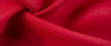 Yumuşak kıvrımlı, pürüzsüz, akışkan kırmızı kumaş ve canlı, dokulu yüzey zengin ve sıcak estetik bir cazibe yaratıyor..