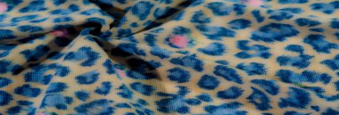 Soyut mavi leopar desenli kumaş bej rengi katmanlı yumuşak pembe çiçek aksanlı, lüks moda veya çağdaş dekoratif projeler için ideal..