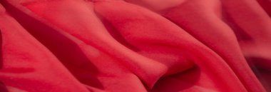 Canlı kırmızı kumaş bulanıklığı, zarif kıvrımlar ve yaratıcı çabalar için lüks ve görsel olarak zengin tekstil yüzeyini vurgulayan pürüzsüz dokular..