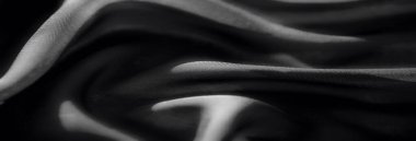 Görüntü, ince kıvrımları ve gölgeleri olan, ince siyah kumaş, ince desen, derinlik ve ince gölgeler. Zarif perdeleri olan tek renkli bir kompozisyon..