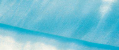 Bulanık, açık mavi kumaşın yumuşak parıltısı narin kıvrımlarla parlar, ışığı yakalayıp sanatsal zarafetle akan yumuşak, ipeksi bir doku yaratır..