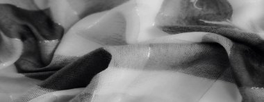 Bulanık - Gri tonda yumuşak kıvrımlı kumaşın karmaşık bir görüntüsü. Işık ve gölgenin hassas etkileşimi sanatsal ve minimalist cazibesini arttırır..