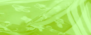 Görüntü. İnce kıvrımlar ve pürüzsüz bir doku ile geliştirilmiş, zarif çiçek desenleri ile parıldayan yeşil yarı şeffaf bir kumaş. Uyumlu ve görsel olarak çekici bir kumaş tasarımı yaratıyor.