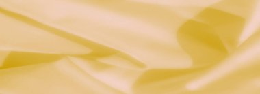 Bulanık sarı kumaş, tasarım ve dekoratif kullanım için sıcak ve sofistike bir doku sunarak pürüzsüz kıvrımlar ve nazik gölgeler sergiliyor.