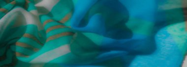 Canlı bir turkuaz kumaşın bulanık, narin kıvrımları ve parlak bir parıltısı var. Işığı güzel yansıtan, zarif dekorlar için mükemmel bir dokuya sahip..