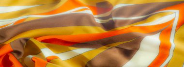 Zengin turuncu, sarı ve kahverengi tonlara sahip canlı kumaş bulanıklığı. Karmaşık çizgiler ve yumuşak, akıcı bir doku. Sıcak, lüks bir tekstil deseni yaratıyor..