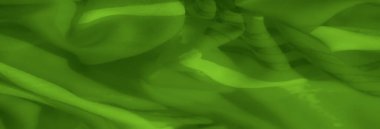 Yumuşak ve pürüzsüz yeşil kumaştan ince kıvrımlar ve karmaşık dokular, soyut tasarımlar veya arka planlar için canlı bir renk ve hassas bir akış sergiliyor..