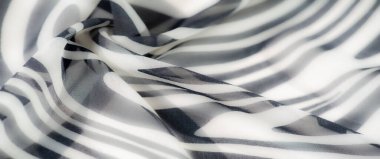 Çizgili, soyut tasarımı ve pürüzsüz dokusu olan bulanık siyah beyaz kumaş. Katlar boyutu ekler, modern kullanım için dinamik ve çok yönlü bir görünüm yaratır.