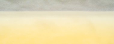 Yumuşak, sarı bir kumaşın bulanık ve yumuşak kıvrımları pürüzsüz ve zarif bir doku oluşturuyor. Kumaşın sıcak rengi, çeşitli dekor ve tasarım arkaplanları için uygun rahat bir his katar..