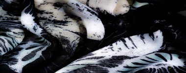 Beyaz aksanlı ruhani siyah örgü kumaşı bulanıklaştırır. Yumuşak kıvrımlar, karmaşık detaylar ve soyut tekstil bileşiminde akan desenler içerir..