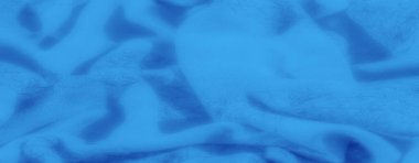 Dalgalanan kıvrımları ve yumuşak, pürüzsüz bir yüzeyi olan canlı mavi kumaş bulanıklığı, sakin ve dingin bir dokuyla tekstil sanatının zarafetini yakalıyor..