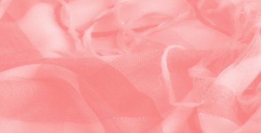 Karmaşık yıpranmış iplikleri olan yumuşak mercan renkli kumaş bulanıklığı, ışığı yansıtıyor ve tasarım ilhamları veya arka planlar için lüks, sıcak bir ortam yaratıyor.