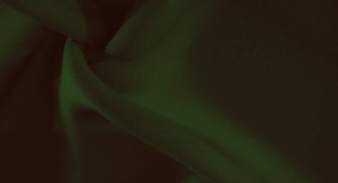 Zarif yumuşak kıvrımları ve gölgeleri olan bulanık yeşil kumaş, pürüzsüz dokusunu sergiliyor ve tasarım için ideal soyut desenler yaratıyor..