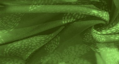 Yumuşak kıvrımları ve doğal motifleri olan yeşil kumaşın üzerindeki bulanık etki huzur verici bir zemin oluşturur. İnce yaprak benzeri desenler, tekstil yüzeyine organik ilgi ekliyor..
