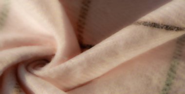 Bulanık, ince kıvrımlı pembe kumaş ve kesişen yeşil ve kahverengi ekose çizgiler doğal ışık altında hassas ve samimi bir doku oluşturuyor. Tekstil temaları için mükemmel.