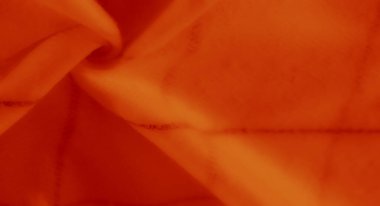 Yumuşak turuncu kumaş bulanıklaşır, belli belirsiz bir çizgisel dizaynla, parlak tonları ve pürüzsüz dokuları kusursuz ve davetkar tekstil yüzeyine harmanlar..