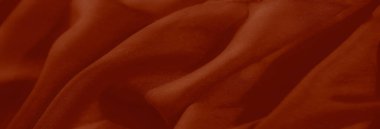 Bulanık kırmızı renkli kumaş kıvrımları ve ince ışık etkileşimini yakalar, tasarım, dekor veya sanatsal amaçlar için mükemmel desenli ama yumuşak bir yüzey sunar..