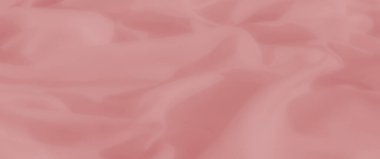 Hassas, pürüzsüz kıvrımlı bulanık pembe kumaş sanatsal tasarımlar veya tekstil fotoğrafçılığı için sakin ve sofistike bir arkaplan yaratır.