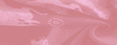Yumuşak pembe kumaşın bulanık görüntüsü çiçek aksanlı karmaşık bir fil motifi dokumayı ve zarafeti vurgulayan kıvrımlar halinde kıvrılarak kıvrılıyor..