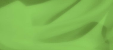 Görüntü yeşil kumaşın ince kıvrımlarını güçlendiriyor, hafif ve pürüzsüz özelliklerini sergiliyor. İnce kıvrımlar ve derinlik onu arka plan ya da doku tasarım elementleri için ideal kılar.
