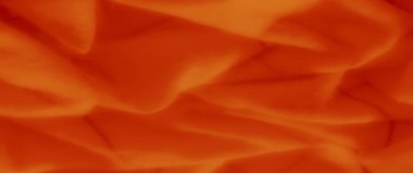 Yumuşak, akışkan kıvrımlı ve narin dokuları olan ılık turuncu kumaş soyut ve modern projeler için zarif, sanatsal bir zemin oluşturur..