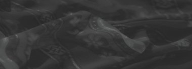 Belirgin siyah kumaş, kabileden esinlenilmiş desenler ve çiçek aksanıyla. Kalıplı yüzey, genel bileşime derinlik ve incelik ekler..