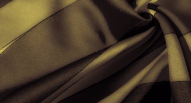 Görüntü. Pürüzsüz, siyah çizgili, çarpıcı kıvrımlarla dizayn edilmiş sarı kumaş zengin bir doku sergiliyor ve tekstile lüks bir cazibe katıyor..