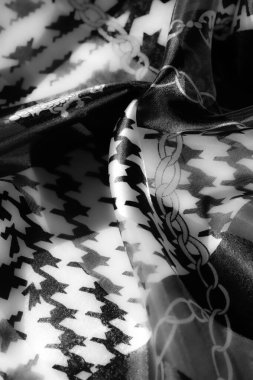 Monokrom kumaş sergiler koyu zincir motifler houndstooth desenler ile birleştirilmiş, klasik ve modern tasarımlar büyüleyici kıvrımlar ile harmanlanır.