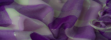 Çağdaş tekstil ve dekoratif uygulamalar için sofistike ve büyüleyici bir doku sunan parıltılı detaylar ve yumuşak kıvrımlar içeren bulanık mor kumaş..