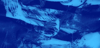 Görüntü. Soyut desenler ve beyaz aksanların kombinasyonu olan mavi kumaş, dokulu yüzeyi ve dinamik bir görsel efekt için pürüzsüz akış kıvrımları ile geliştirilmiş..