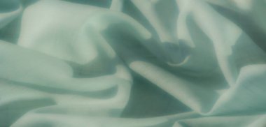 Hassas ızgaraları ve yumuşak gölgeleri olan nane rengi kumaş bulanıklığı, estetik bir cazibe için kusursuz bir doku ve doğal ışık etkileşimi yakalıyor..