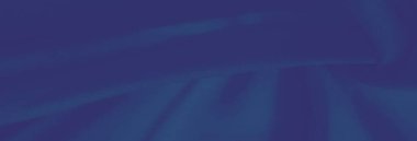 Bulanık mavi kumaş, belirgin kıvrımları ve narin bir dokusu var. Yumuşak gölgeler bırakıyor ve soyut ya da moda görselleri için mükemmel bir hareket hissi yaratıyor..